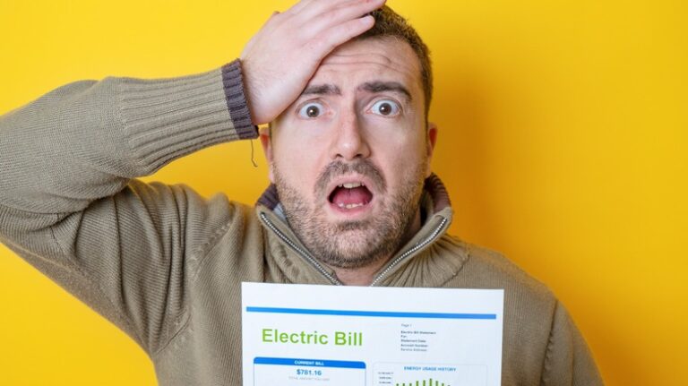 Shocked,Man,Reading,Some,Bills,Energy,Expenses,Isolated,On,Yellow
